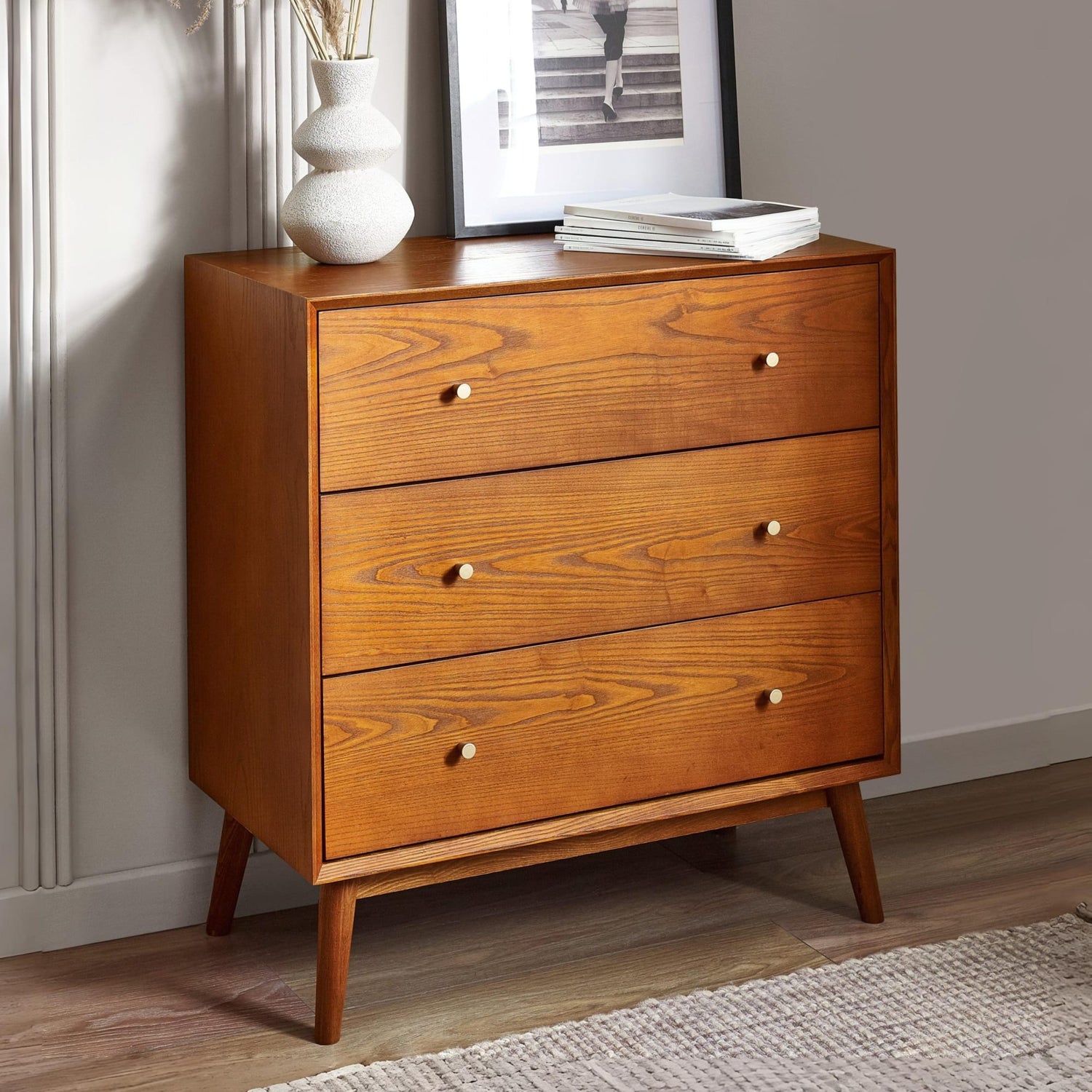 Wooden dresser with three drawers in a room setting