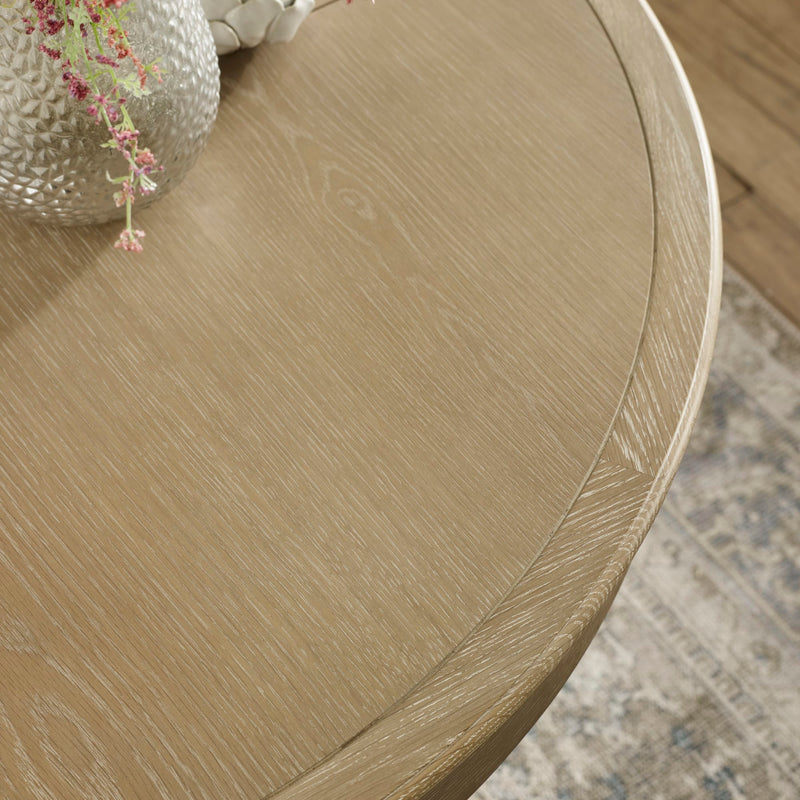 Round wooden table with a textured surface on a patterned rug