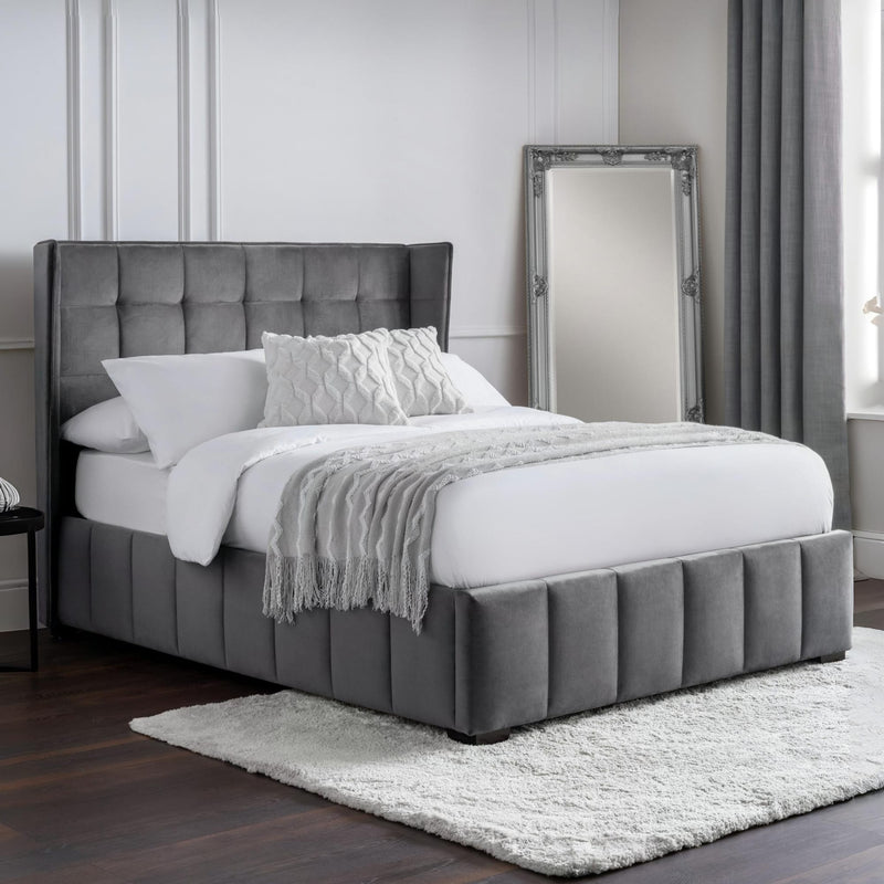 Gray upholstered bed with white bedding in a bedroom setting