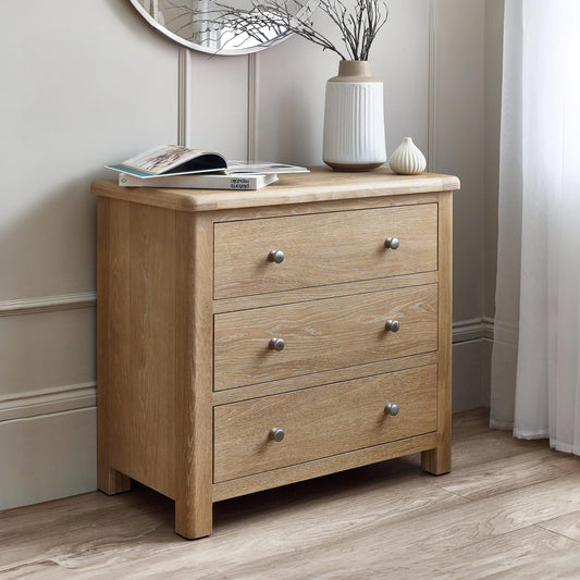 Wooden dresser with three drawers in a room setting.