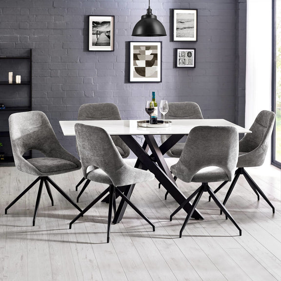 Dining room with a round table and gray chairs against a gray brick wall.