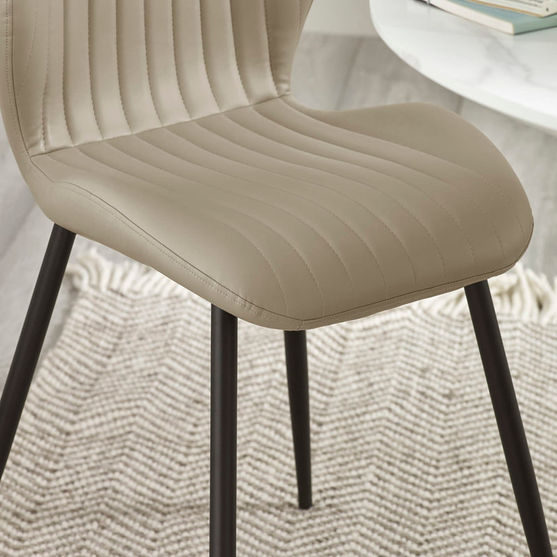 Beige chair with black legs on a textured surface