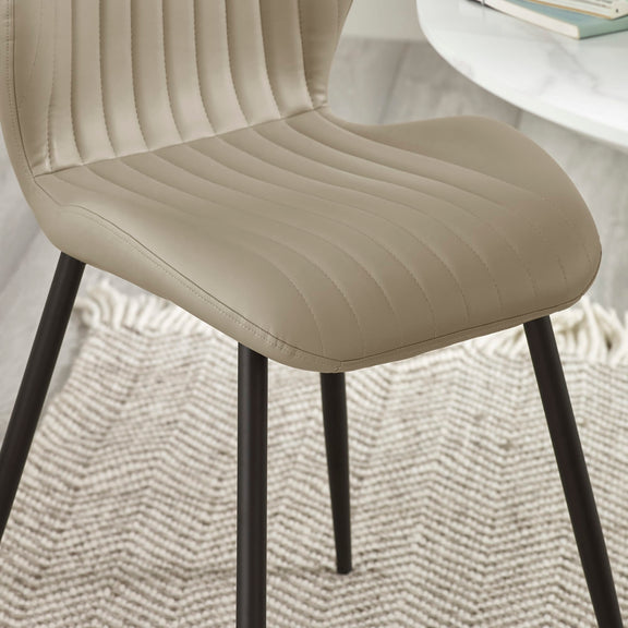 Beige chair with black legs on a textured surface