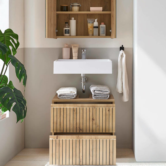 Bathroom with wooden vanity, sink, and shelves with toiletries.