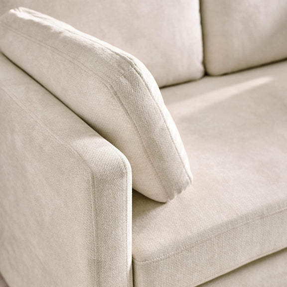 Close-up of a beige sofa with a textured fabric surface.