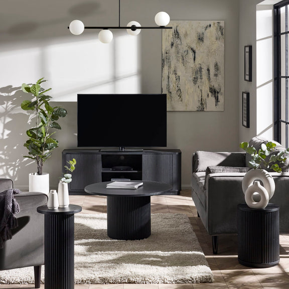 Modern living room with gray sofa, coffee table, and decorative items.