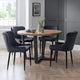 Dining room with a round wooden table and six dark chairs on a wooden floor.