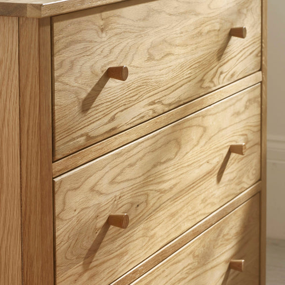 Wooden dresser with three drawers and brass handles.