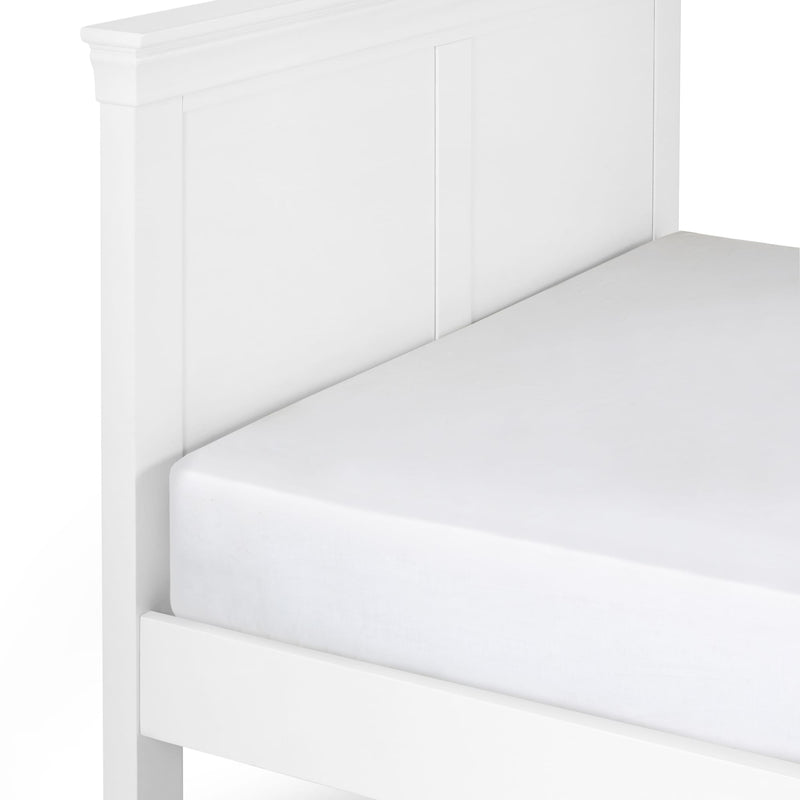 White bed frame with a fitted sheet on a white background