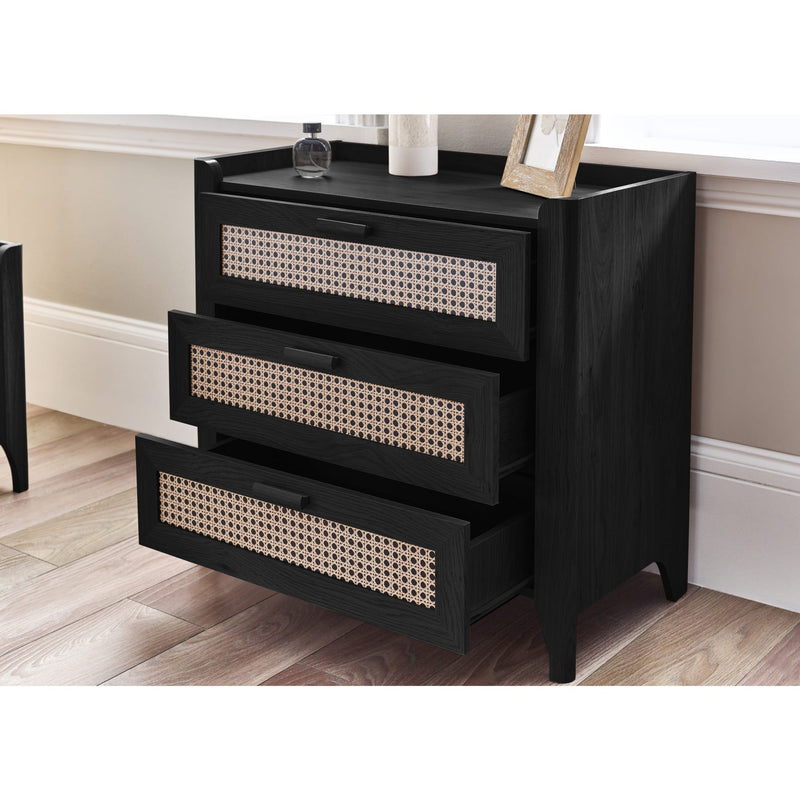 Black dresser with wicker-style drawers in a room setting