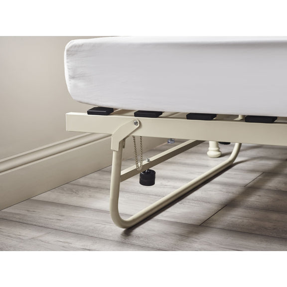 White bed frame with mattress on a wooden floor.