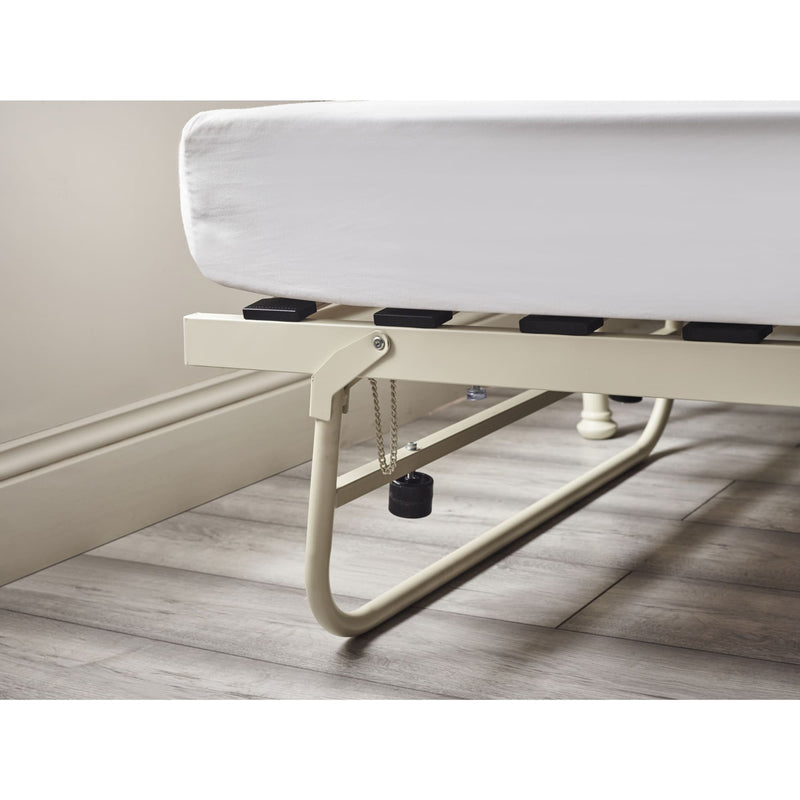 White bed frame with mattress on a wooden floor.