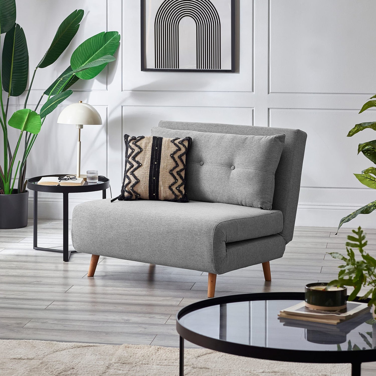 Gray sofa with decorative pillows in a modern living room setting.