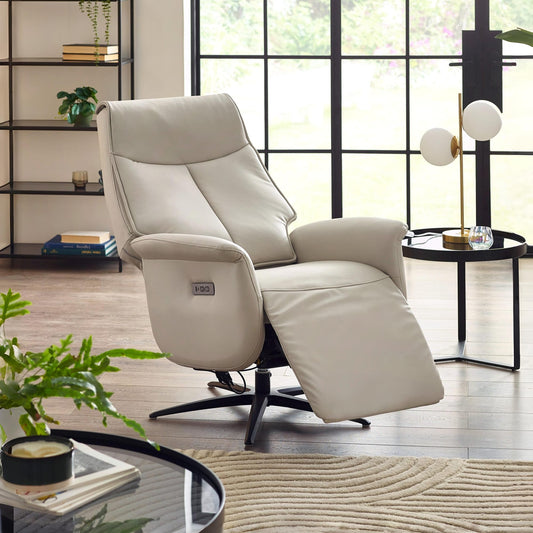 Beige recliner chair in a modern living room setting with large windows.