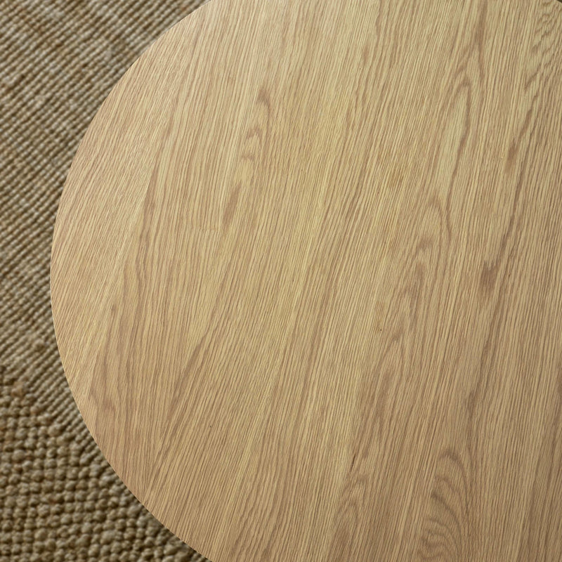 Close-up of a wooden round table corner on a textured surface
