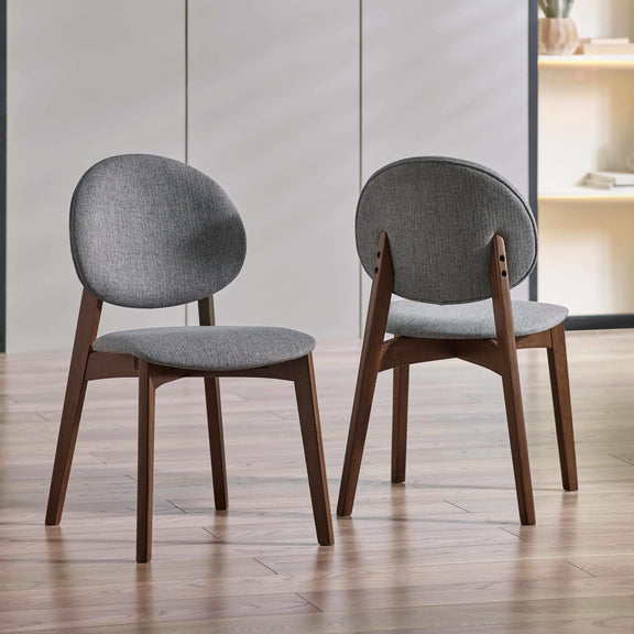 Two gray upholstered chairs with wooden legs on a wooden floor.