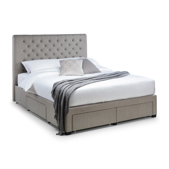 Gray upholstered bed with white bedding and a gray throw blanket on a white background