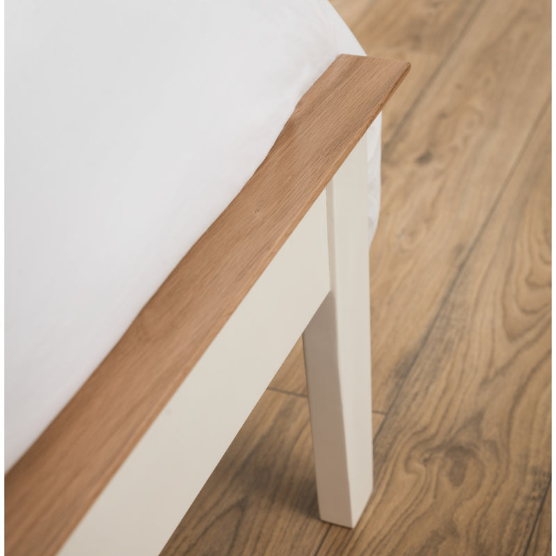 Close-up of a wooden bed frame corner on a wooden floor.
