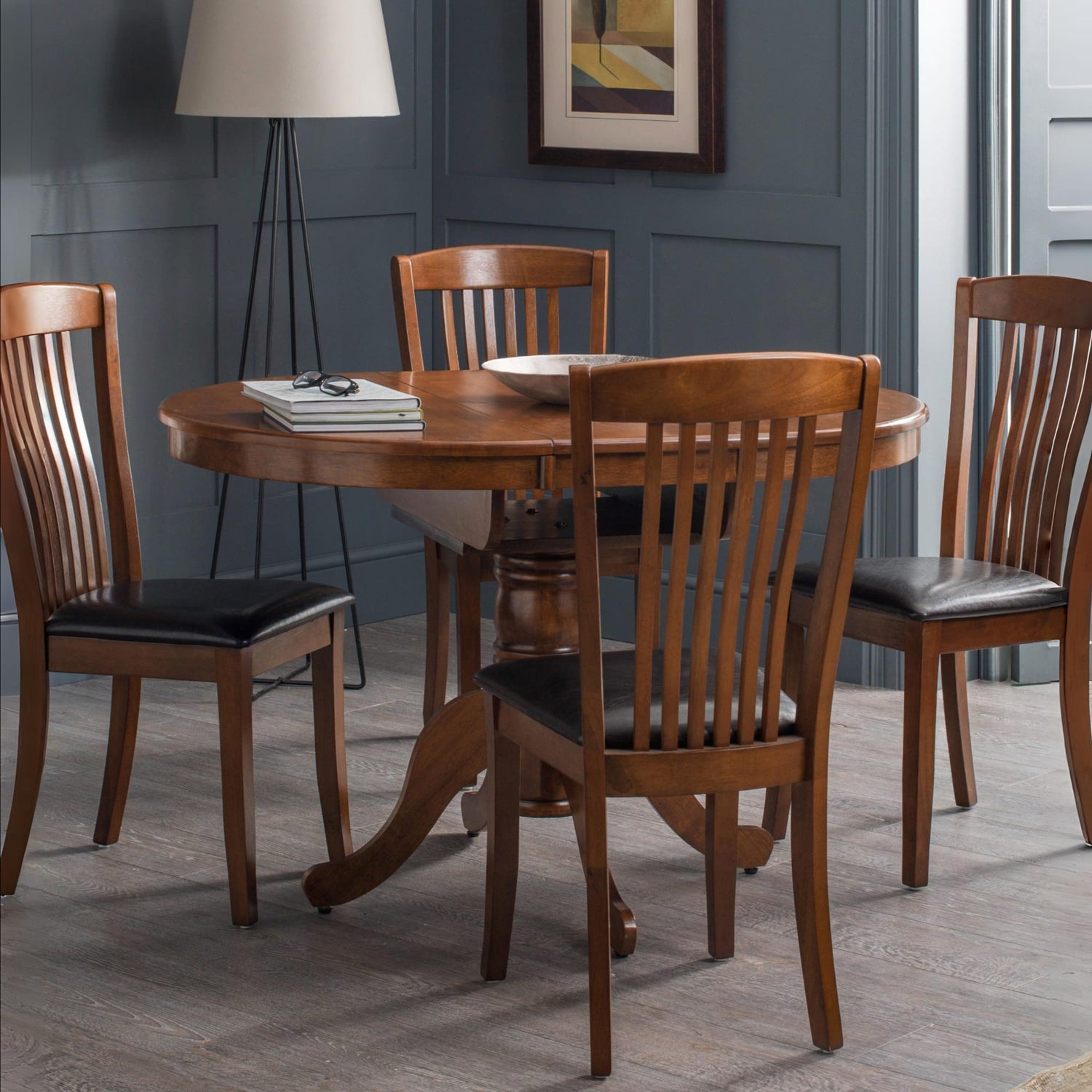 Dining room with wooden table and chairs against a gray wall.