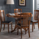 Dining room with wooden table and chairs against a gray wall.