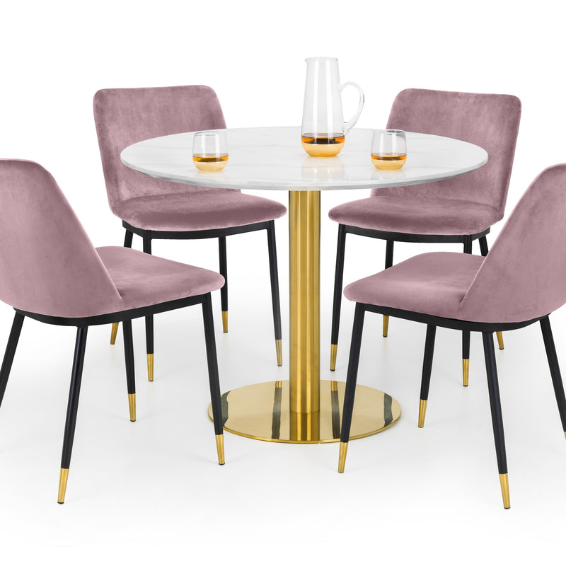 Dining table set with four pink chairs and a gold-painted base on a white background