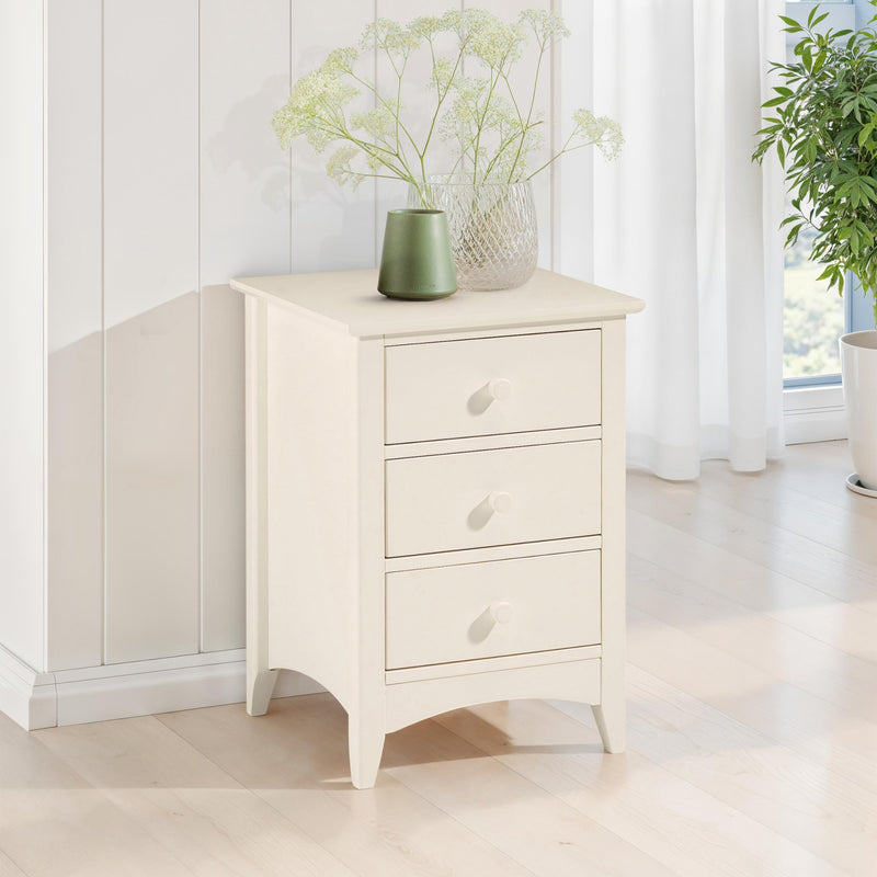 White nightstand with three drawers in a bright room with plants