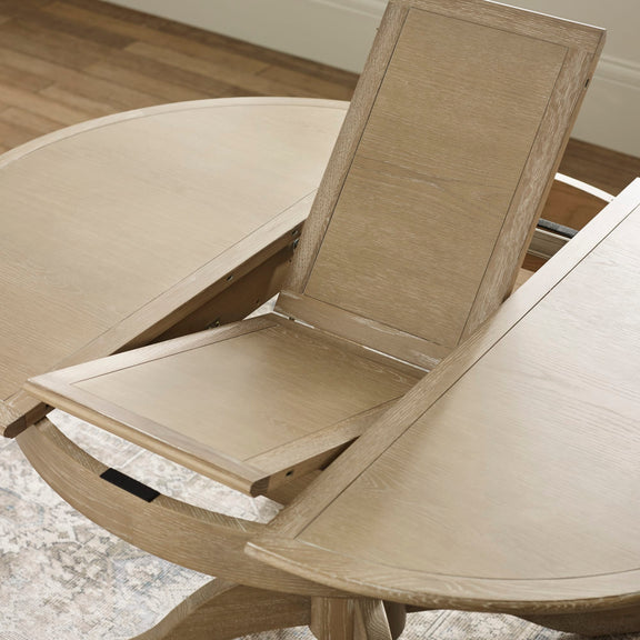 Wooden dining chair with a round wooden table in a room setting.