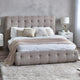 Beige upholstered bed with tufted headboard in a modern bedroom setting.