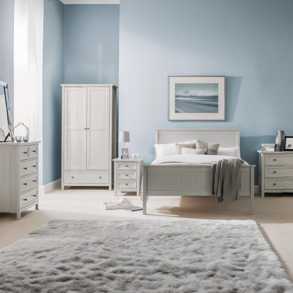 Neatly arranged bedroom with light gray furniture against a light blue wall.
