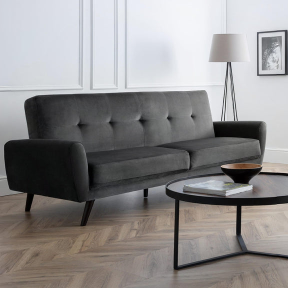 Gray sofa in a modern living room with a coffee table and lamp.