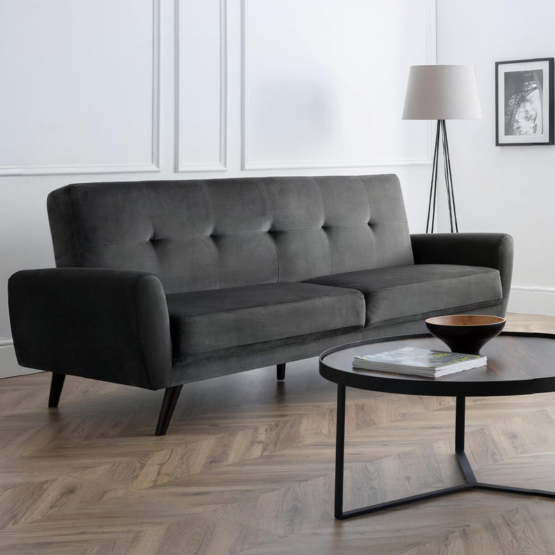 Gray sofa in a modern living room with a coffee table and lamp.