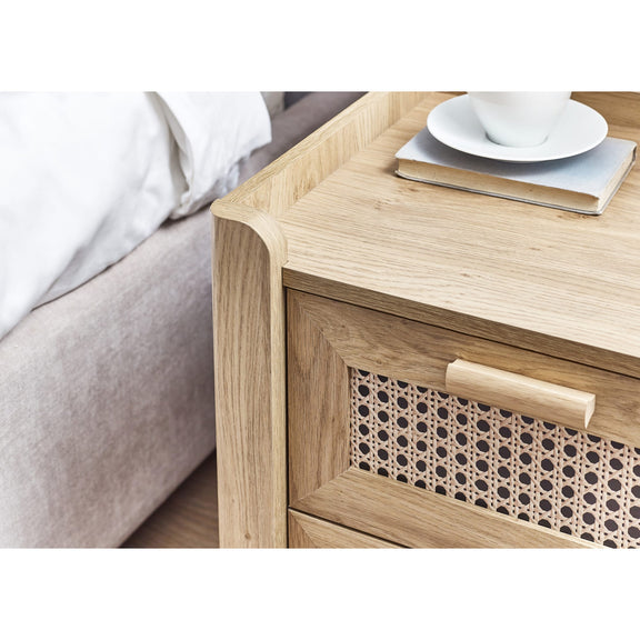 Oak bedside cabinet with drawer open storing books and accessories