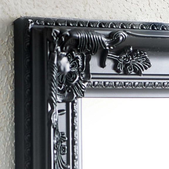 Decorative black frame with intricate details on a light gray wall.