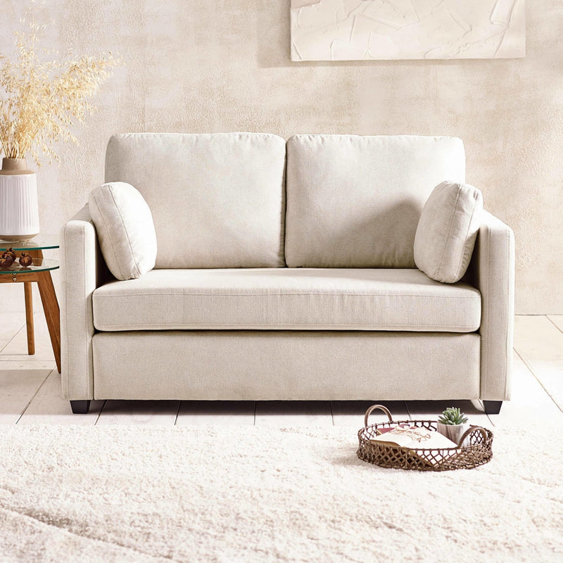 Beige sofa in a living room setting with a neutral color palette.