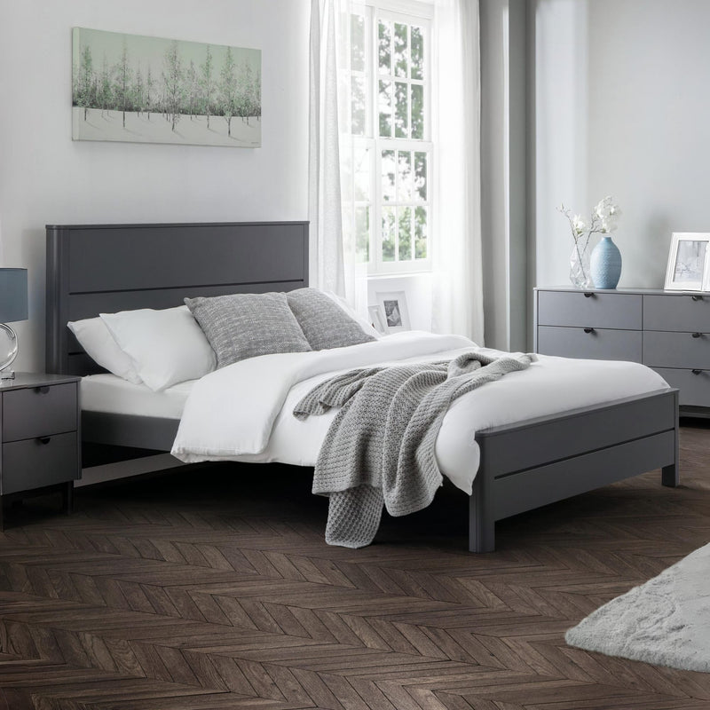 Modern bedroom with gray bed frame, white bedding, and decorative elements.
