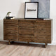 Wooden sideboard with decorative items on a light wood floor and white wall background
