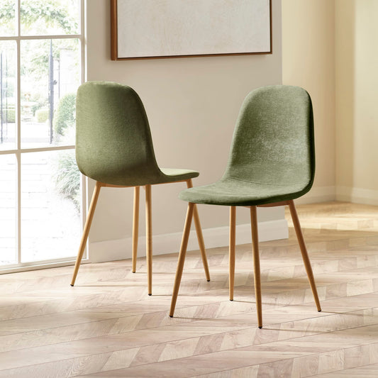 Two green chairs with wooden legs in a room with a large window.