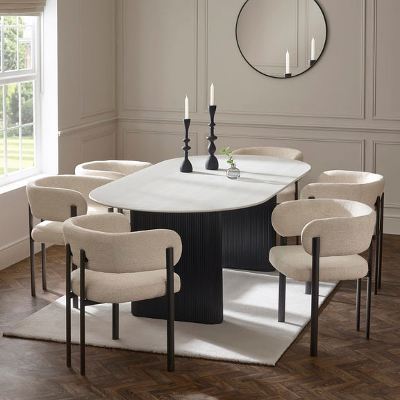 Dining room with a round table and chairs in a well-lit room.