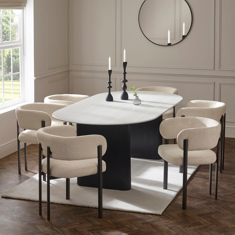 Dining room with a round table and chairs in a well-lit room.