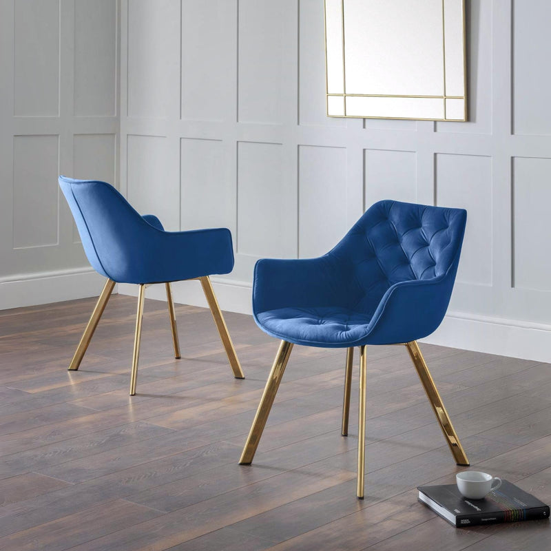 Two blue chairs with gold legs in a room with a white paneled wall.