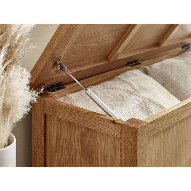 Wooden storage box with a lid open, revealing beige fabric inside.
