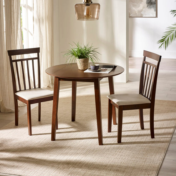 Dining room with a round wooden table and two chairs on a light-colored rug.