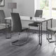 Modern dining room with a glass table and gray chairs on a wooden floor.