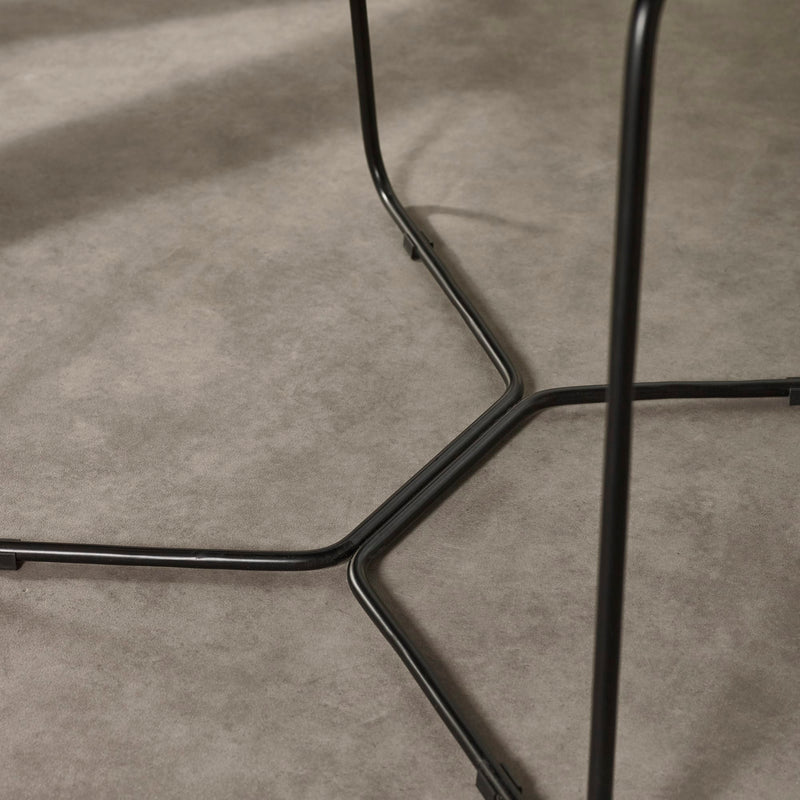 Close-up of a black metal chair frame on a gray concrete floor