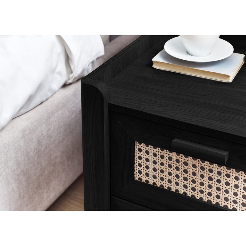 Black bedside cabinet with drawer open storing books and accessories