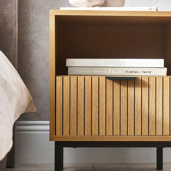 Wooden nightstand with books on a neutral background