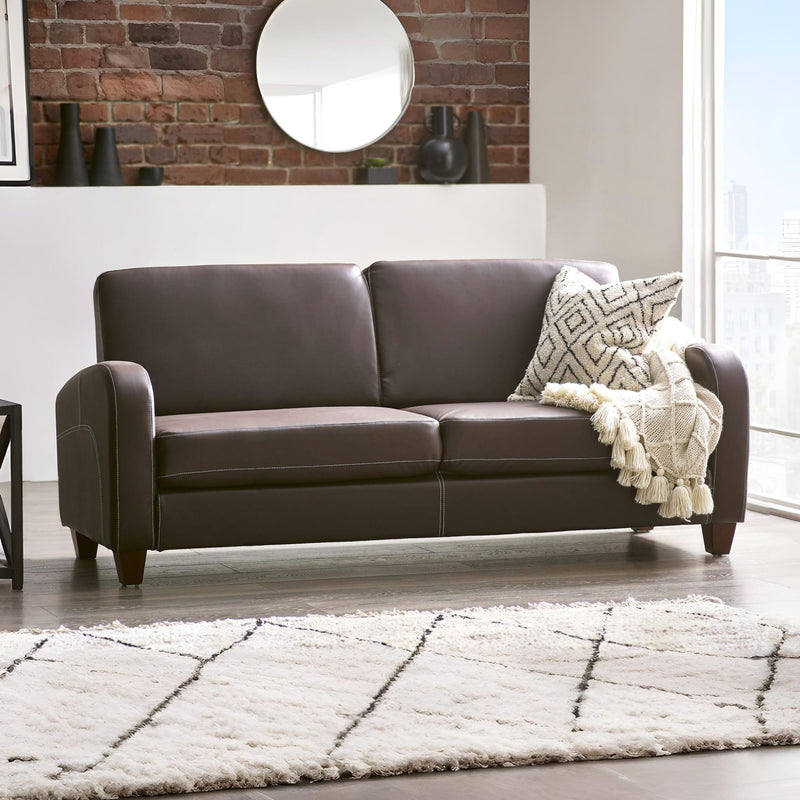 Brown leather sofa with a patterned throw blanket in a living room setting.