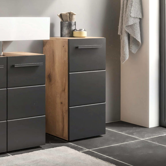 Bathroom vanity with gray cabinets and wooden accents, featuring a towel and toiletries.