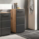 Bathroom vanity with gray cabinets and wooden accents, featuring a towel and toiletries.