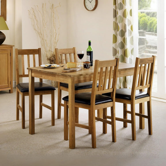 Dining room with wooden table and chairs, wine glasses, and a bottle.